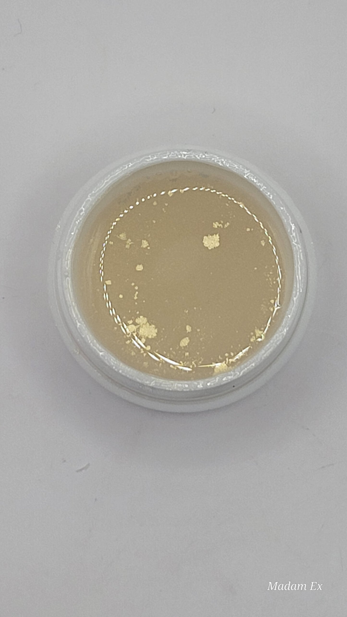 uv jar opened with beige uv hard gel on a gray background top view