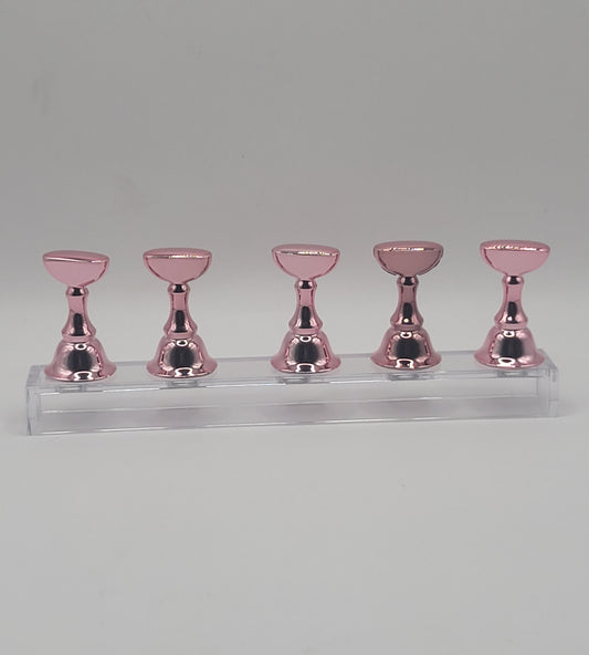 1 Set of five pink nail display stand on a clear stand against a gray background
