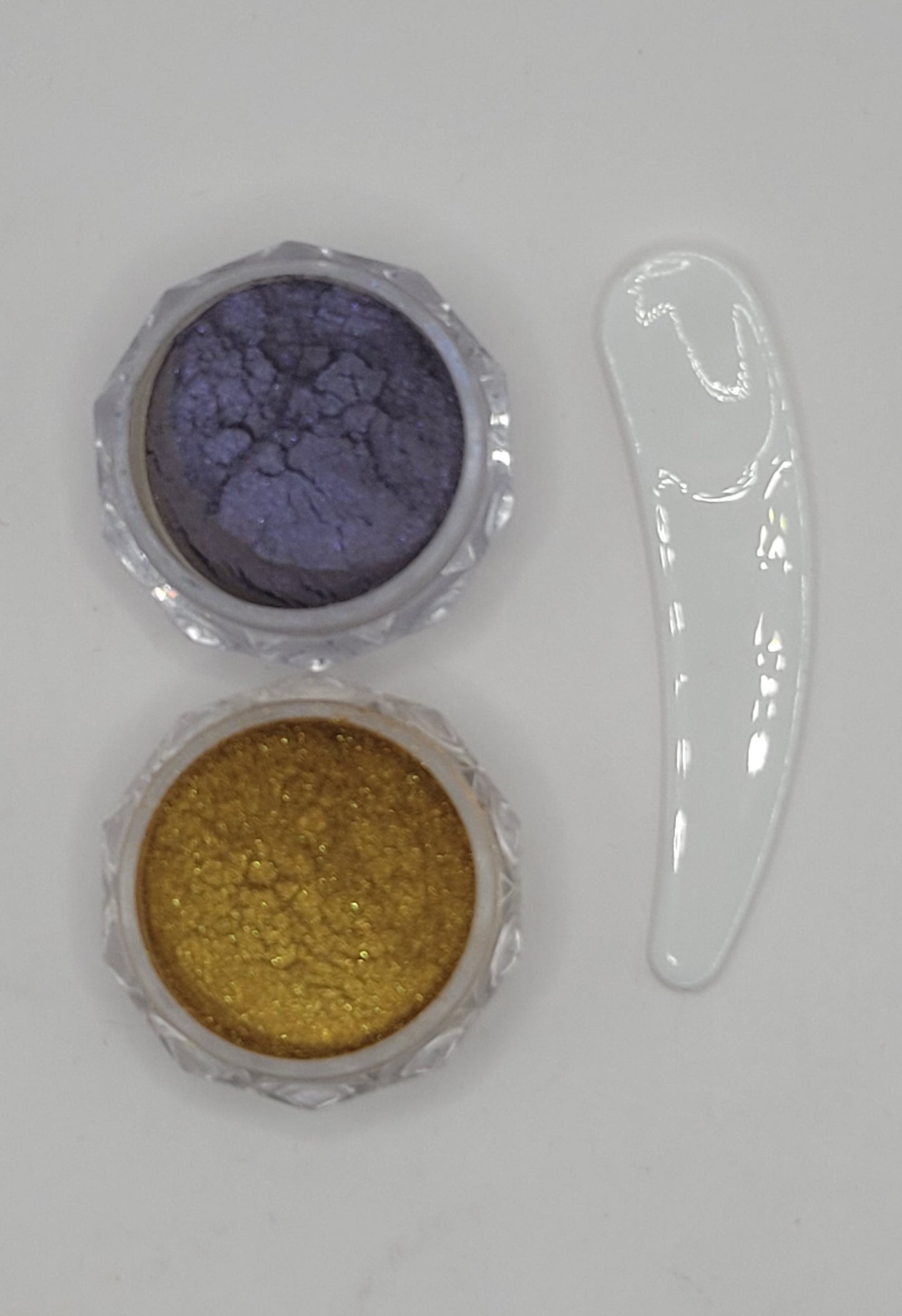 two small containers with cat-eye chameleon powder mix in a clear plastic containers on a white background gold and Purple