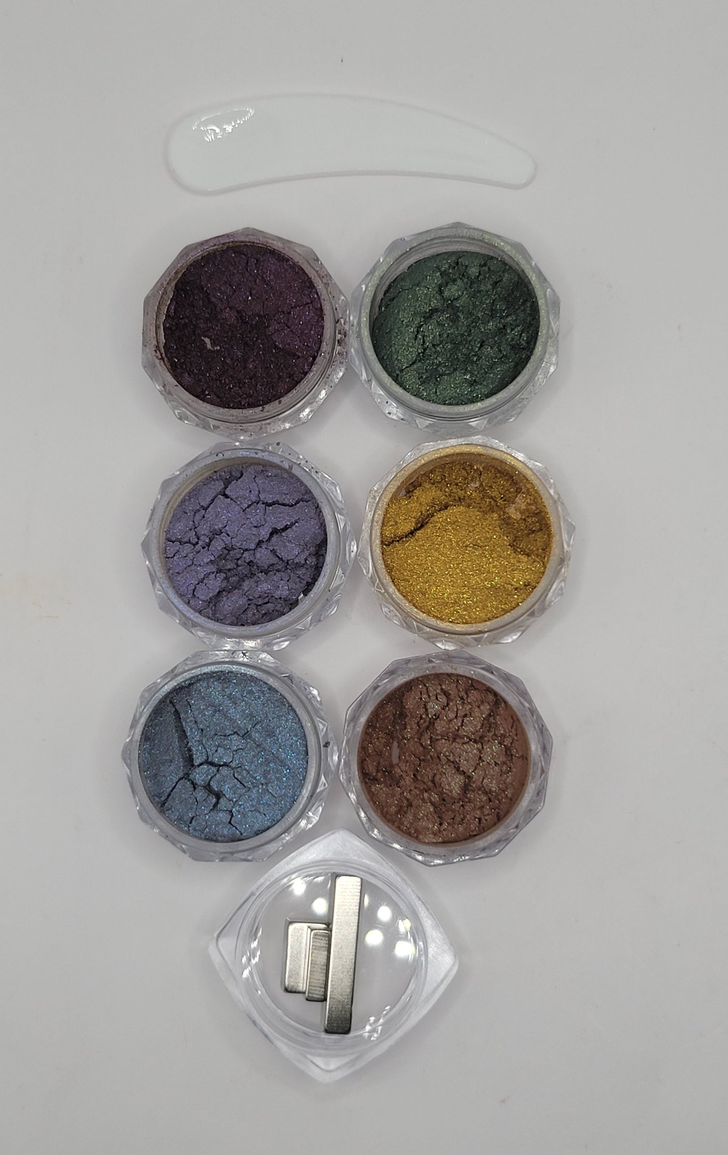 Set of six small containers with cat-eye chameleon powder mix in a clear plastic containers on a white background with 3 mini cat-eye magnets