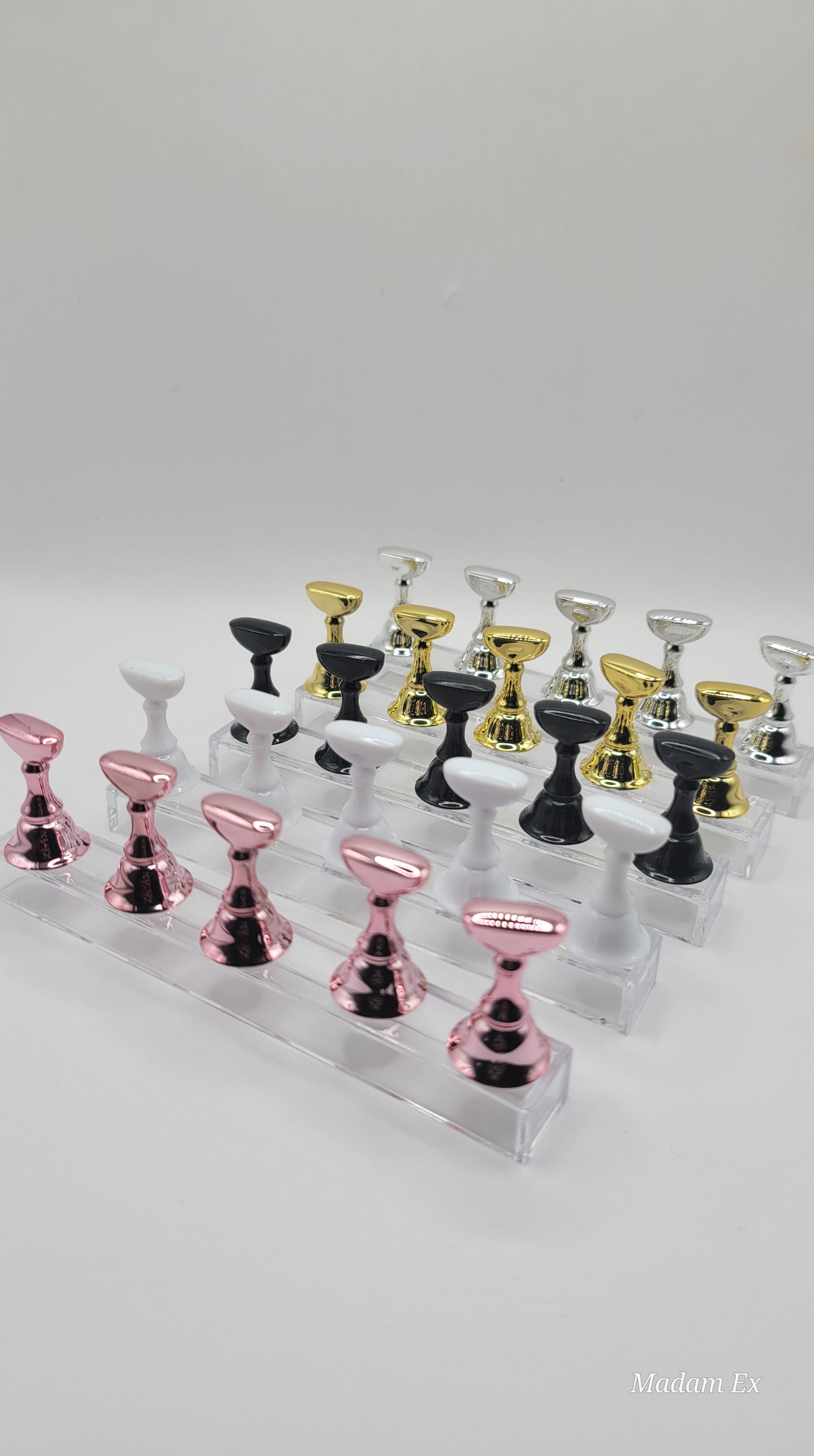 5 Sets of press-on nail display stands in black pink white gold and silver on a white background