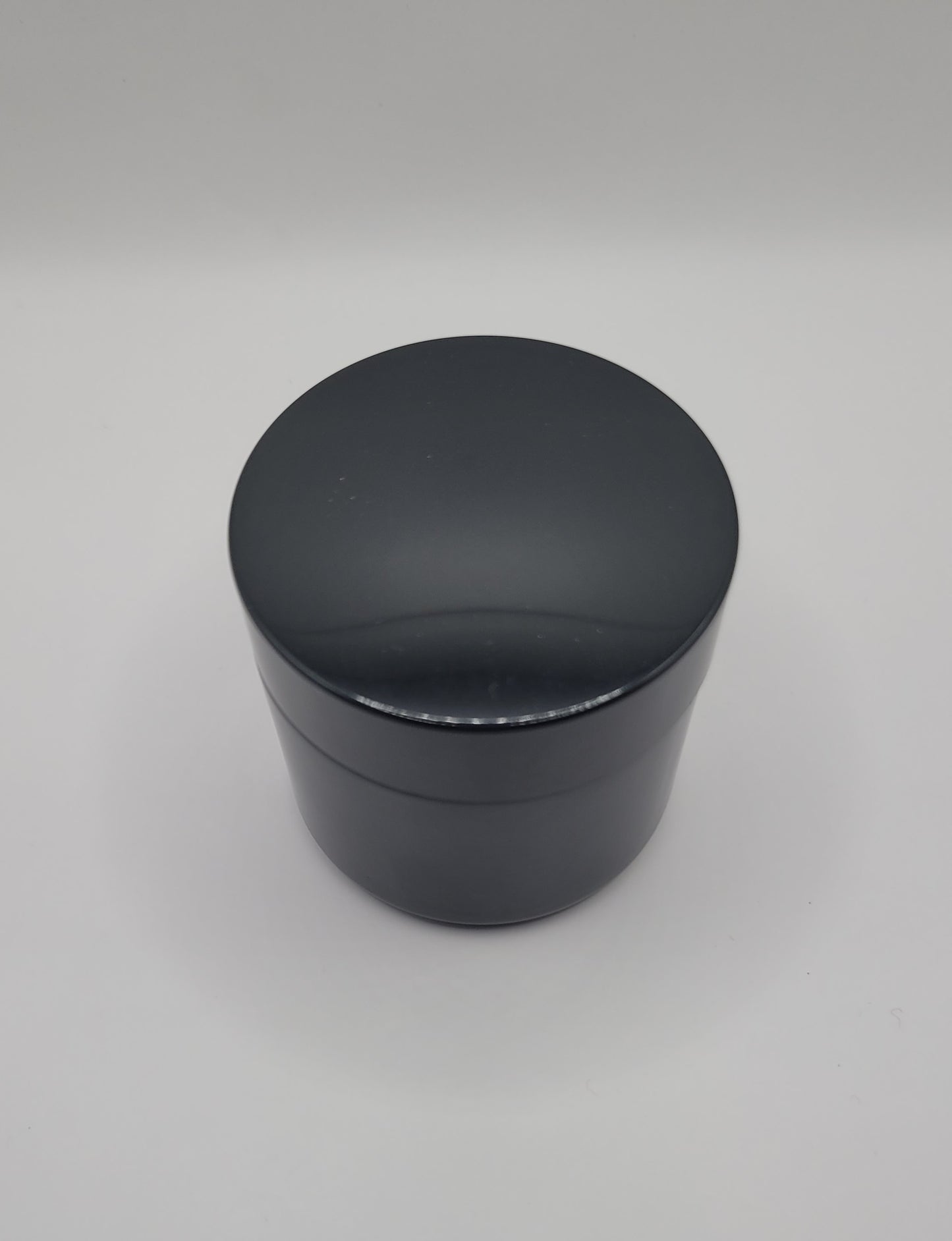 Black cylindrical container on a gray background