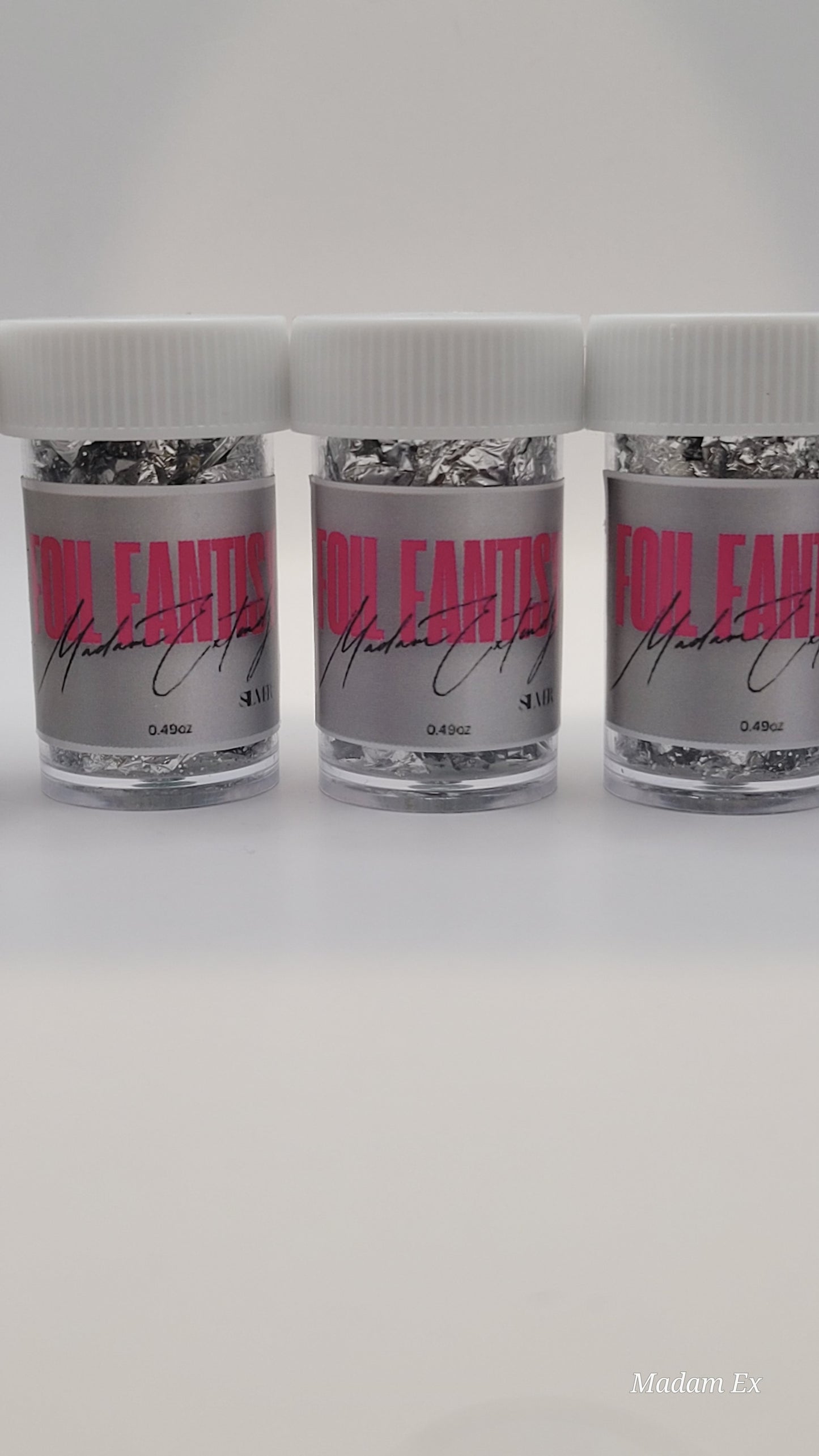 Three containers of silver foil fantasy with pink labels on a white background