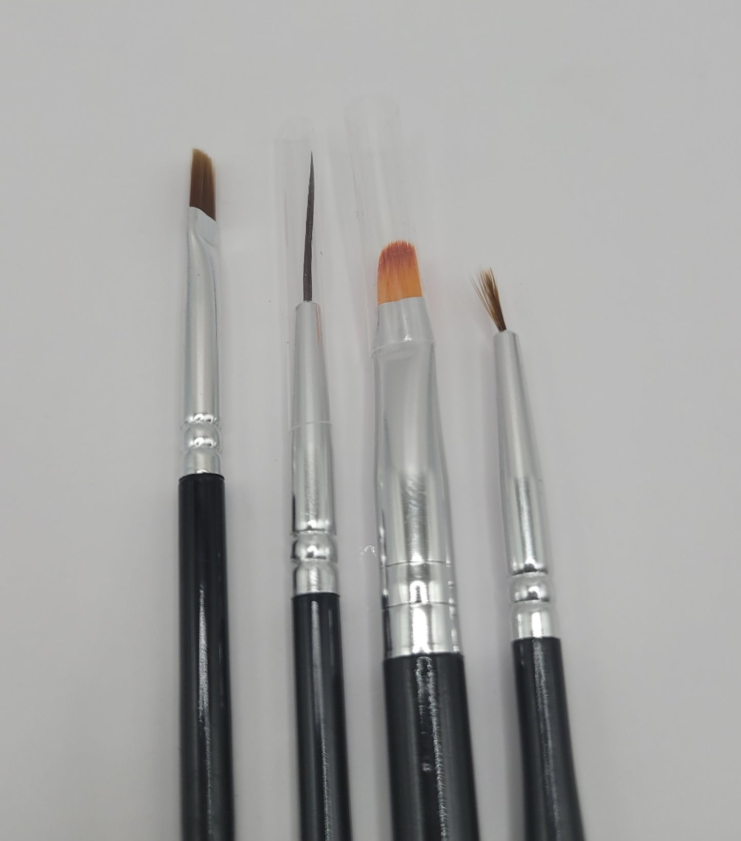 five black and silver nail art brushes on white background