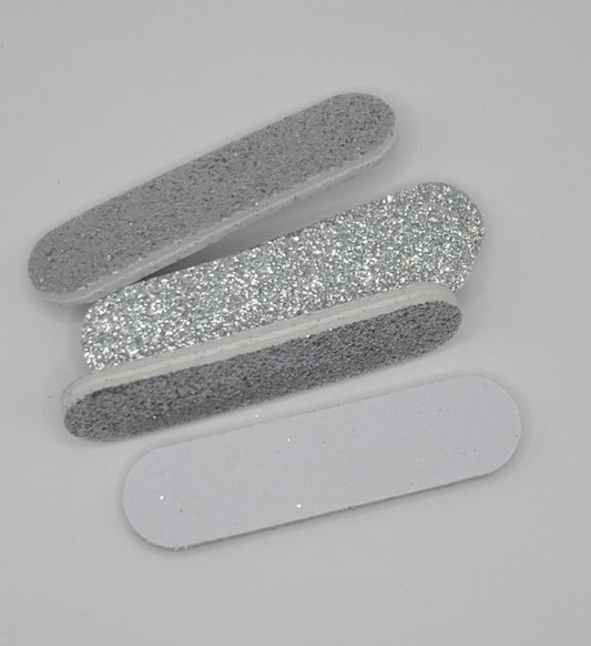 four nail files with glittery and smooth finishes on a light gray background