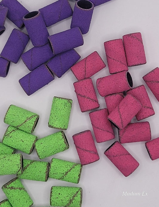 Colorful nail drill bits on a white background