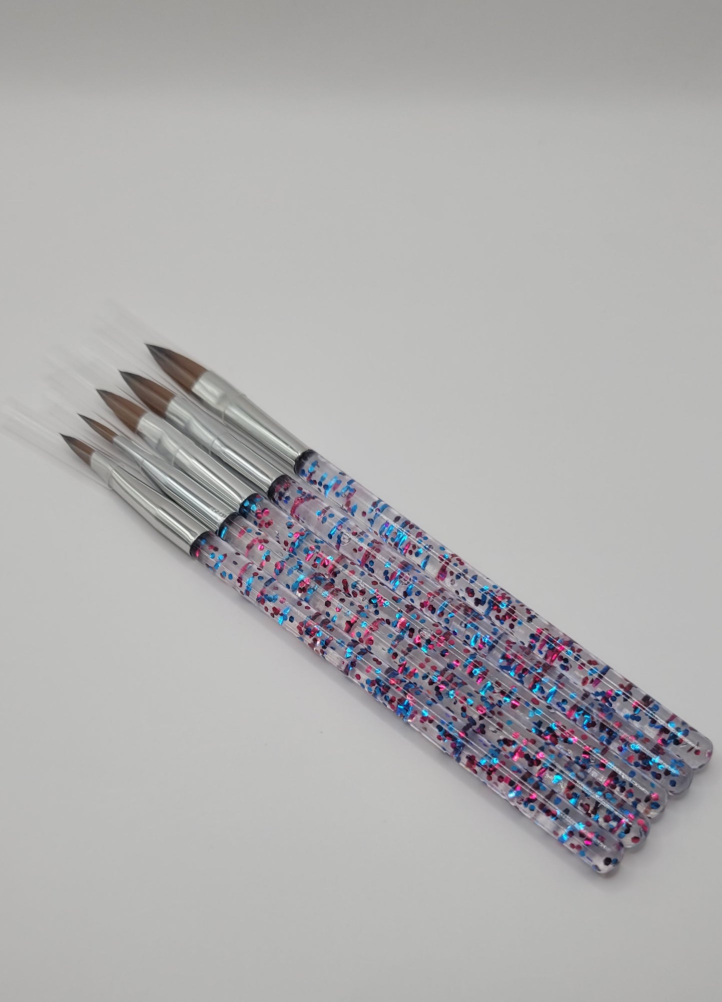 five acrylic brushes on white background