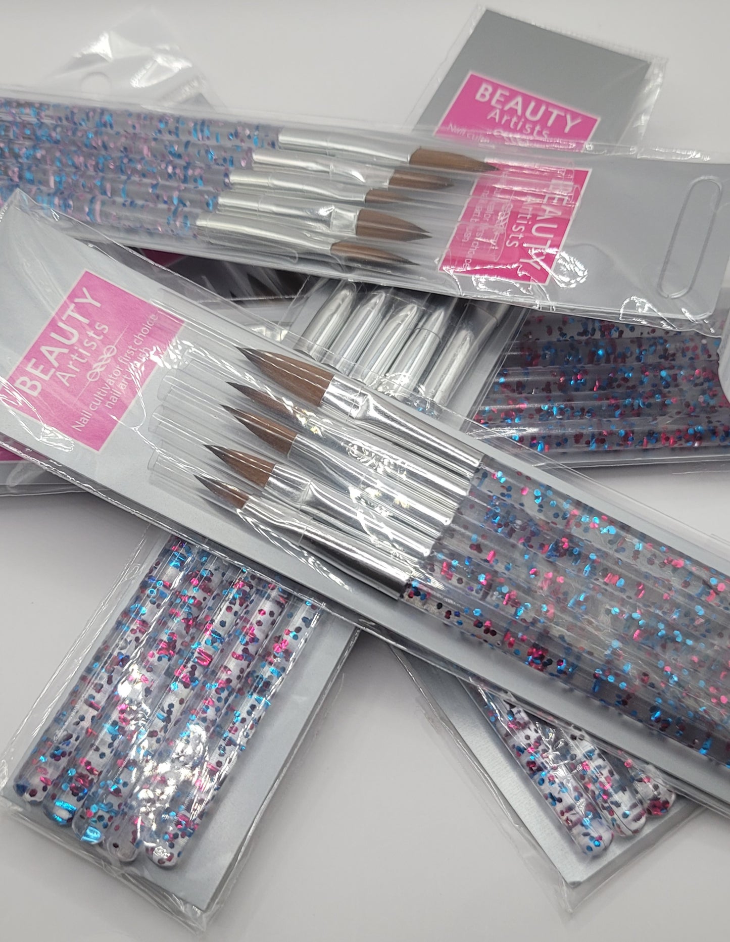 five packs of acrylic brushes in a pile on a whte background