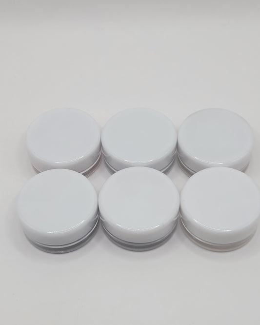 six piece jars with white lids containing mica on a white background