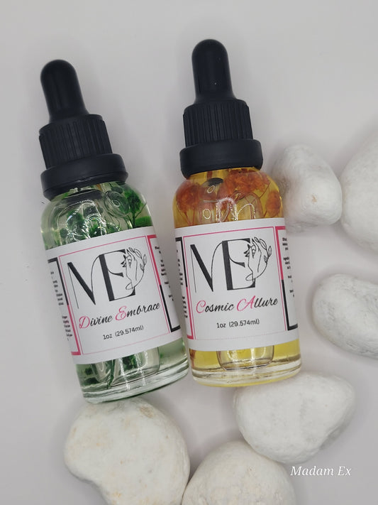 Two bottles of ME cuticle oil with droppers on a white surface with white stones.