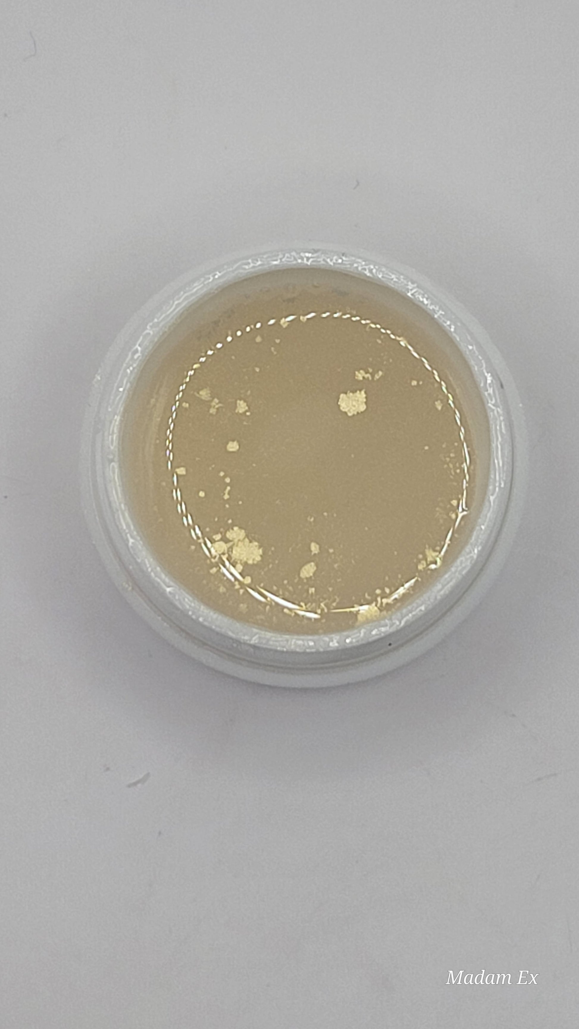 uv jar opened with beige uv hard gel on a gray background top view