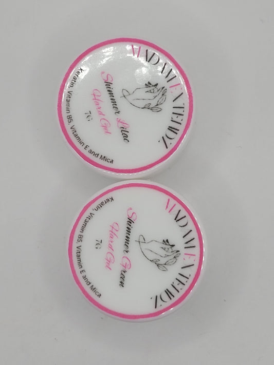 Two small uv containers with white lids and pink writing on a gray background