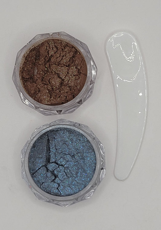 two small containers with cat-eye chameleon powder mix in a clear plastic containers on a white background brown and blue