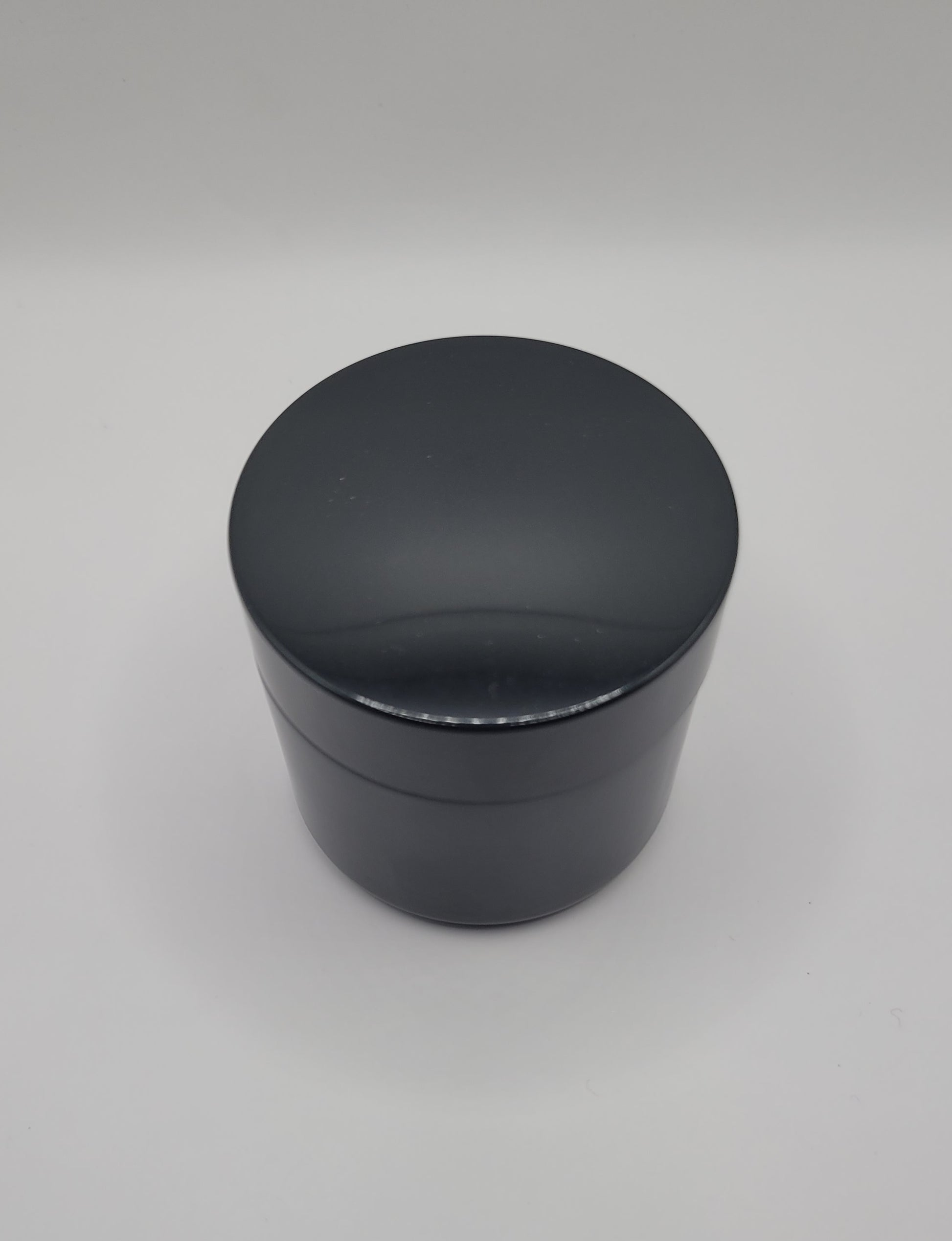 Black cylindrical container on a gray background