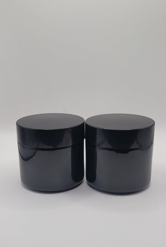 Two black jars with lids on a white background