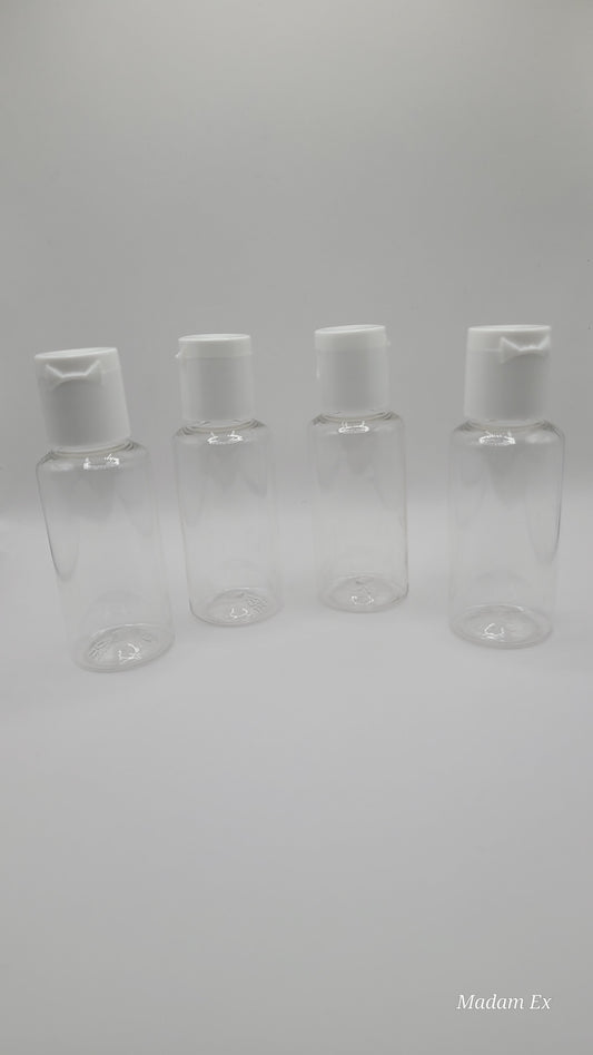 four clear plastic bottles with white tops on a gray background