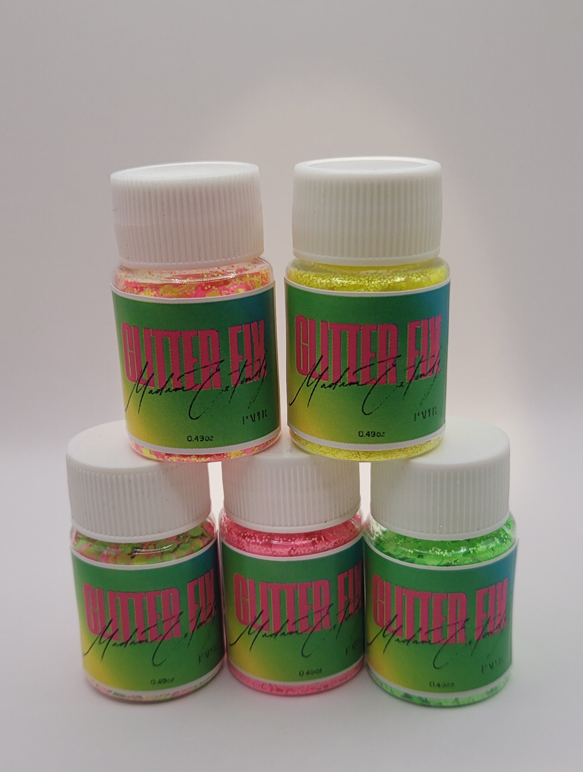 five bottles of Glitter Fix  with green label and pink contents two stacked on top of three on a white background