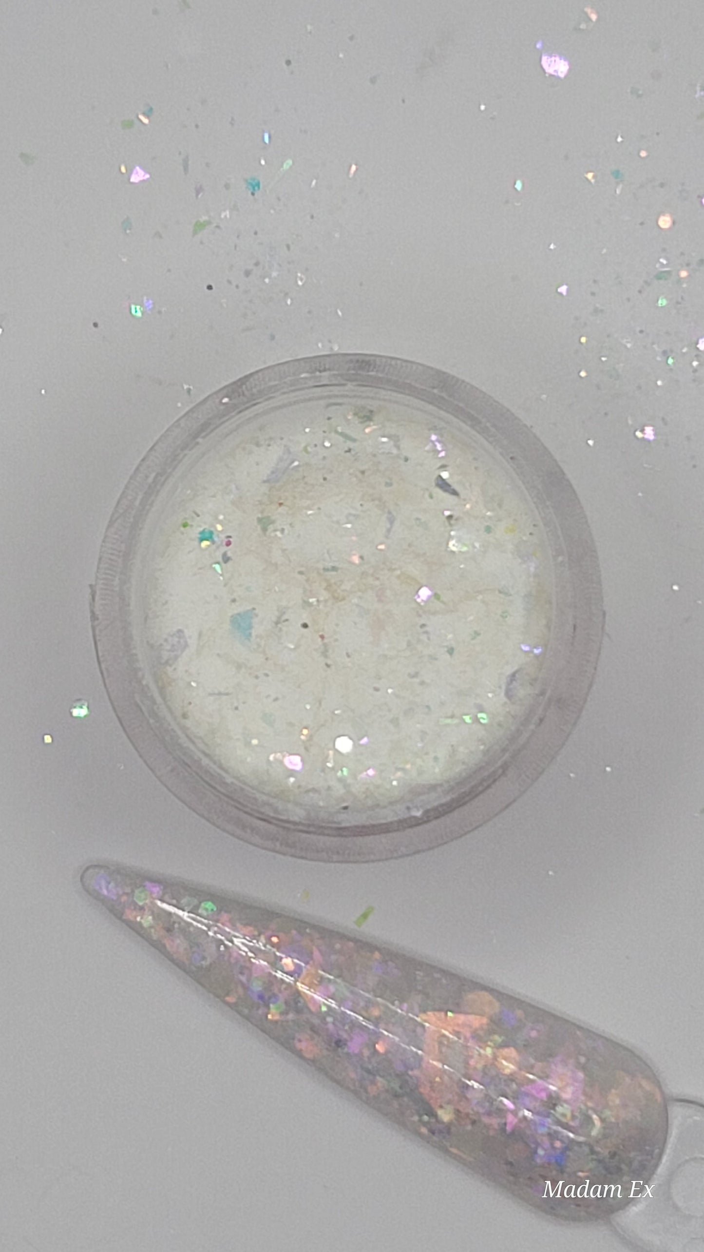 glow in the dark Iridescent glitter acrylic in a jar next to a swatchstick against a light gray background
