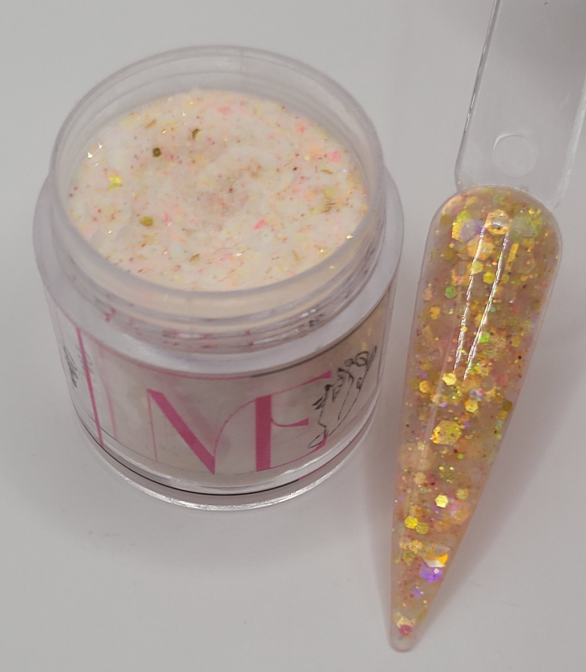 peach glow in the dark Iridescent glitter acrylic in a jar next to a swatchstick against a light gray background