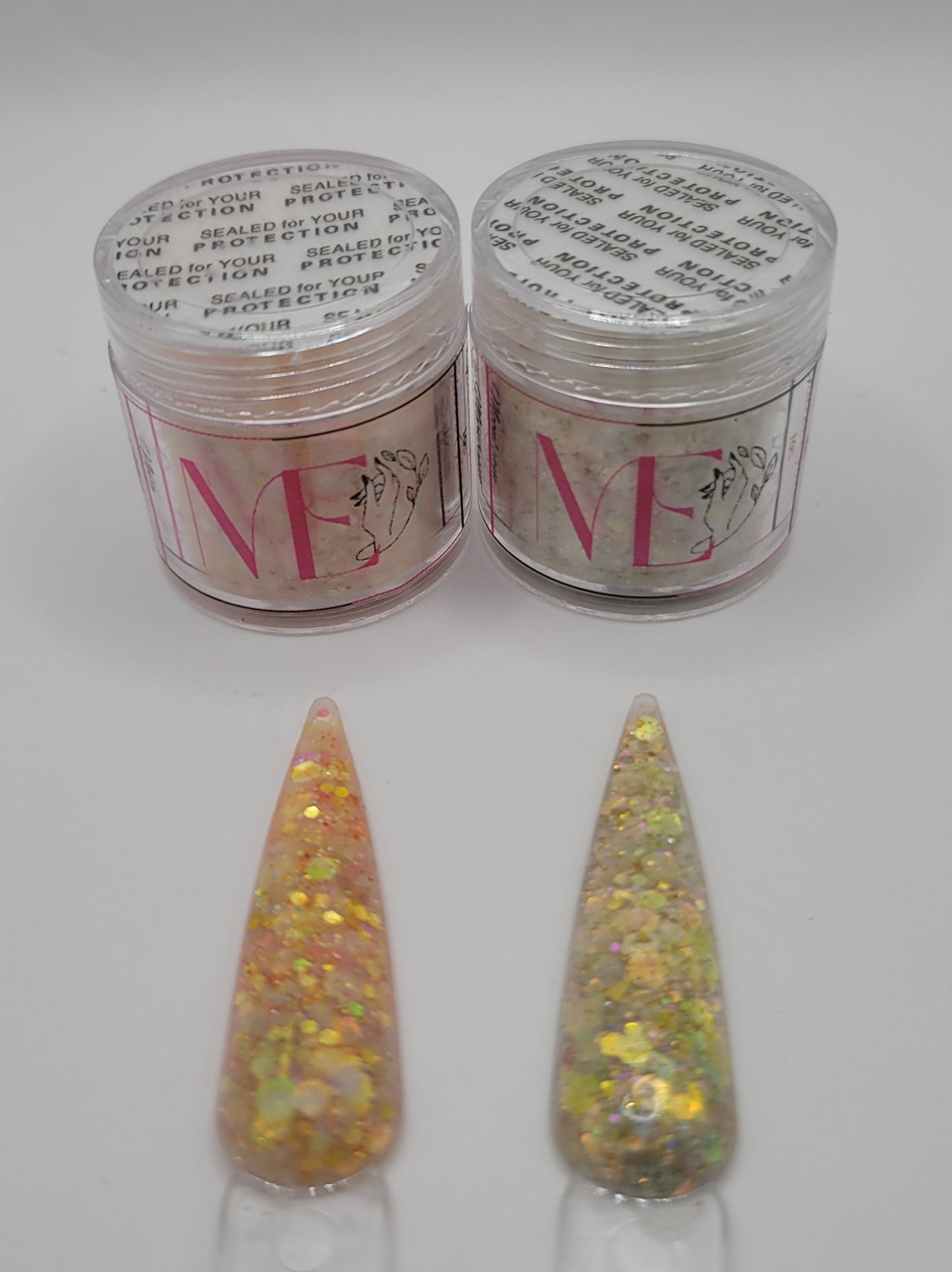 Two jars of glitter acrylic with labels and two glittery nail swatches on a white background