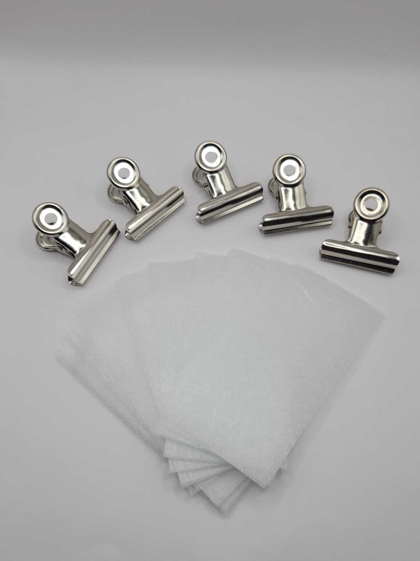 25 piece fiberglass and 5 piece stainless steel clips on a white background
