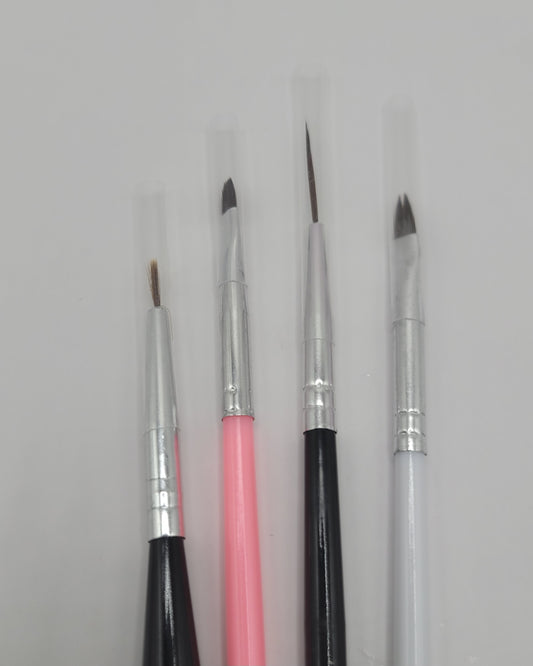 four nail art brushes on white background. 1 pink, 2 black and 1 white 