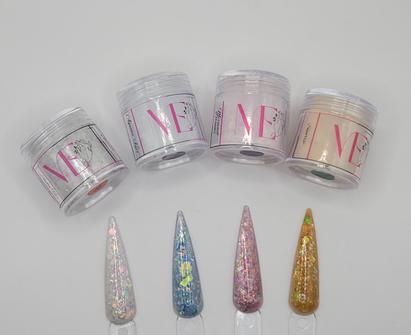 Four jars labeled 'ME' with decorative swatchsticks in front on a white background