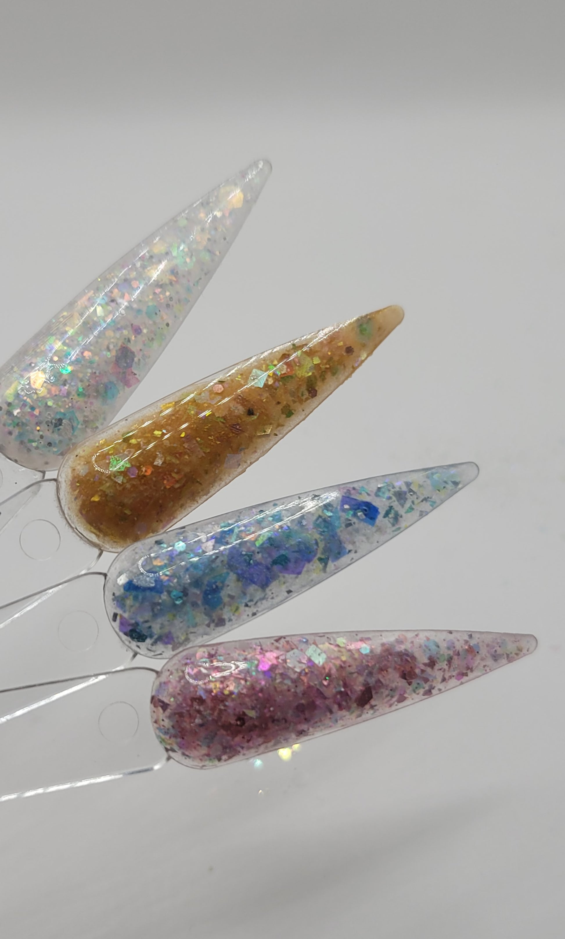 four swatchstick samples of mermaid acrylic powder against a white back ground.