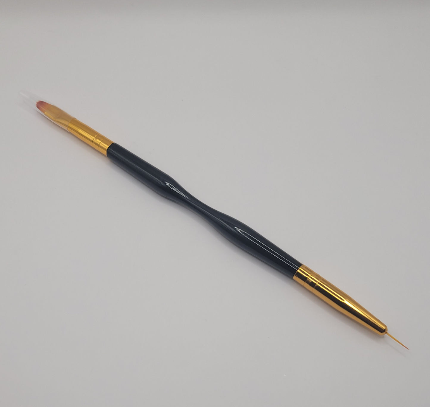 one small tip dual end black and gold nail art brush on white background