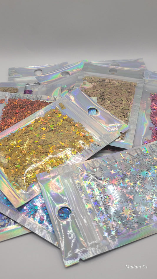 Collection of colorful glitter in packs on a gray background